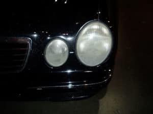 This is a picture of headlights on black car. They are dirty.